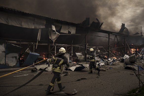 Firefighters work to extinguish a fire in a warehouse amid Russian bombardments in Kharkiv.