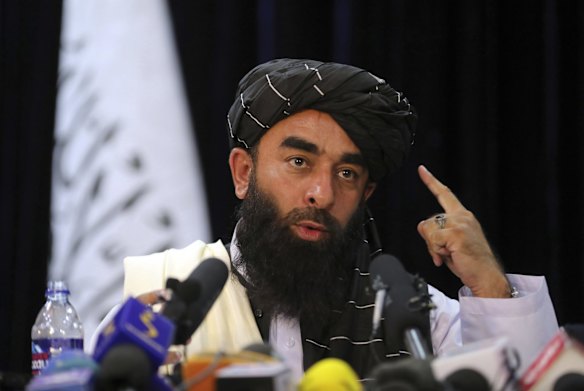 In front of a Taliban flag, Taliban spokesman Zabihullah Mujahid speaks at at his first news conference, in Kabul, Afghanistan. For years, Mujahid had been a shadowy figure issuing statements on behalf of the militants. Mujahid vowed Tuesday that the Taliban would respect women's rights, forgive those who resisted them and ensure a secure Afghanistan as part of a publicity blitz aimed at convincing world powers and a fearful population that they have changed. 