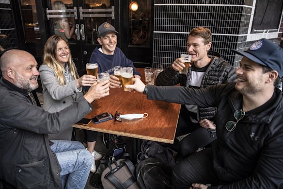 Surry Hills locals, Stuart Gregor, Jen Bailey, Oliver Thomas, Wesley Baimbridge and James Irvine, enjoy a drink at the Dolphin Hotel as the Covid-19 lockdown ends for greater Sydney. 