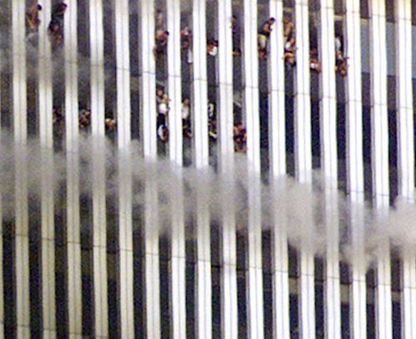 People look out of the burning North tower of the World Trade Center in New York City September 11, 2001.