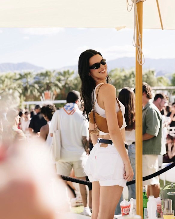 Kendall Jenner in the unofficial Coachella uniform carrying a Kate Spade New York handbag.