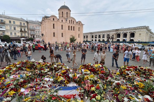 People laiy flowers and light candles in front of the Netherlands Embassy in Kiev on July 18, 2014 in tribute for the 298 people who died after flight MH17 of Malaysia Airlines crashed in rebel-held east Ukraine.  The Boeing 777 came down in cornfields in the separatist-held region yesterday, spraying debris and body parts for kilometres around, with the United States claiming it was shot down in a missile attack.