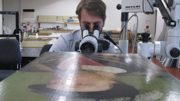 ANU academic Dr Matthew Brookhouse examining the portrait of Henry VIII.