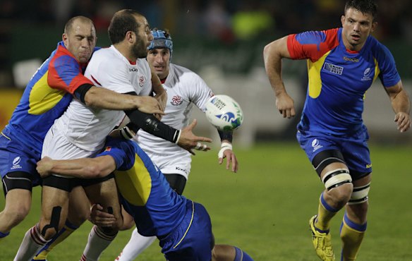 Georgia's Revaz Gigauri gets an offload away despite the attention of the Romanian defence.