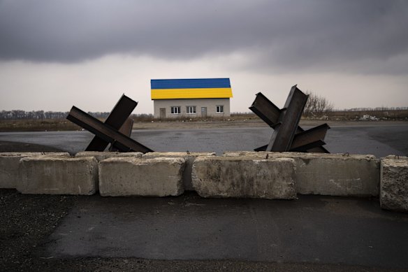 Anti-tank barriers are displayed near a house painted with the colors of the Ukraine flag near Malaya Alexandrovka village, on the outskirts of Kyiv.