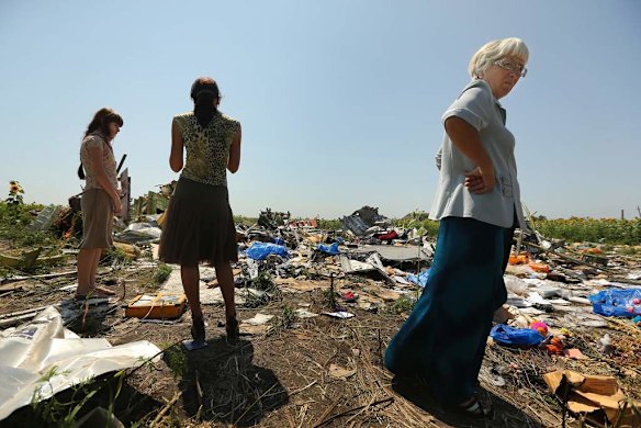 Women look at the debris at one of the sites where the front section.
