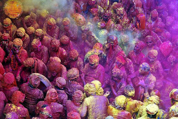 Indian Hindu devotees throw coloured powder at the Radha Rani temple in Barsana, India.