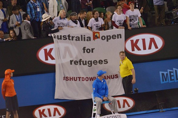 Protesters unfurl a banner at Rod Laver arena during the Men's Final.