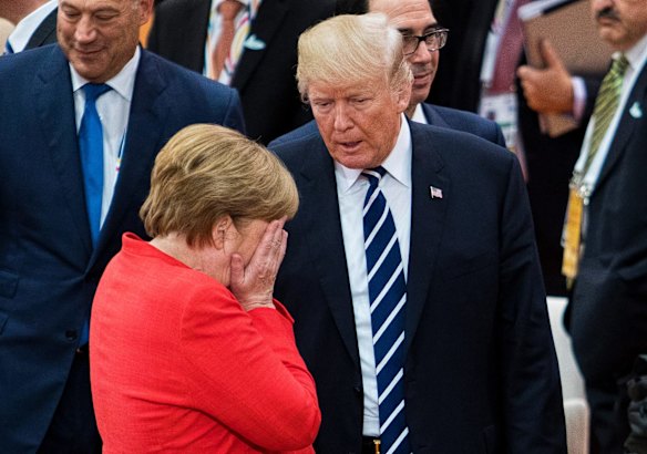 German Chancellor Angela Merkel, front, talks with U.S. President Donald Trump prior to the first working session on the first day of the G-20 summit in Hamburg, northern Germany.