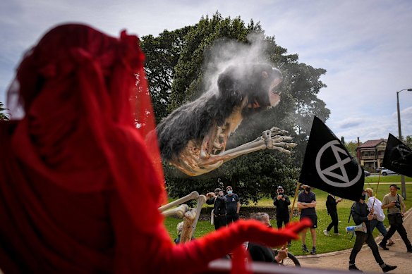 The Extinction Rebellion group’s ‘Red Rebels’ watch as 'Blinky' makes its way through the crowd.