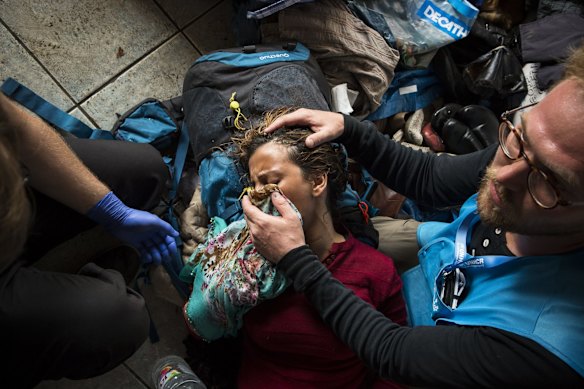 UNHCR workers care for a woman after Hungarian police used tear gas, pepper spray and water canons at the Horgos border crossing in Serbia.V
