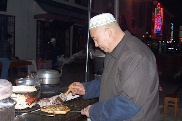 A Muslim hawker prepares bread in Dunhuang's night market. Photo: Joyce Morgan.
