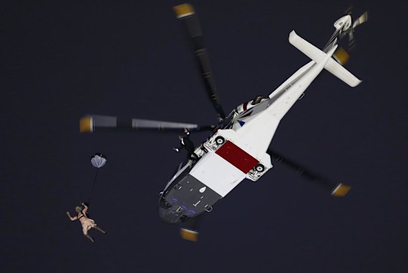 Actors portraying the Queen and James Bond arrive via parachute after jumping from a helicopter during the opening ceremony.
