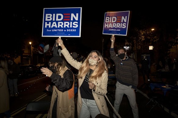 Attendees hold Biden Harris signs during a 2020 U.S. presidential election night watch party in San Francisco, California, U.S.
