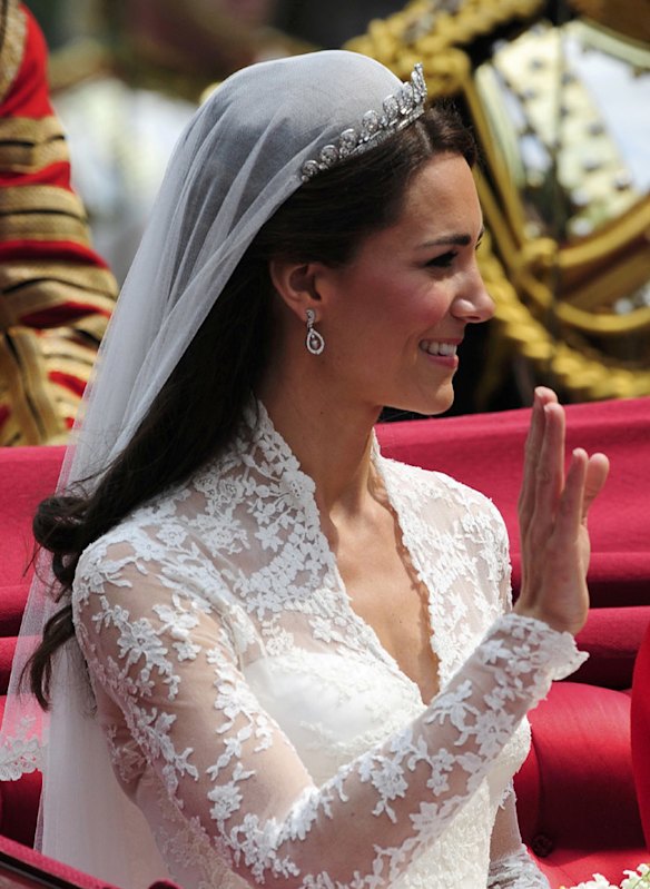Britain's Catherine, Duchess of Cambridge waves as she travels to Buckingham Palace in the 1902 State Landau, along the Procession Route, after her wedding to Britain's Prince William in Westminster Abbey.