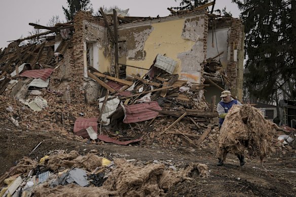 A man removes debris from buildings destroyed during fighting between Russian and Ukrainian forces, outside Kyiv.