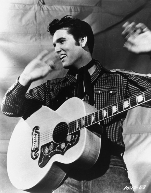 Rock 'n' roll legend Elvis Presley with his Gibson guitar.