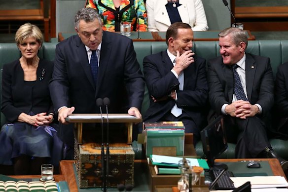 Prime Minister Tony Abbott in discussion with Industry Minister Ian Macfarlane as Treasurer Joe Hockey delivers the Budget speech.