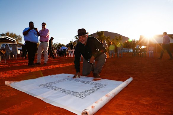 Noel Pearson signs the canvas upon which the Uluru Statement from the Heart was painted. May 2017
