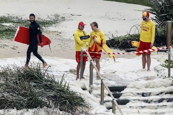 A surfer comes ashore at Tamarama Beach, after being swept in from Bronte Beach.