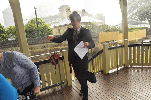 Members of a Andrew Constance press conference run for cover after storm hits Sydney.
