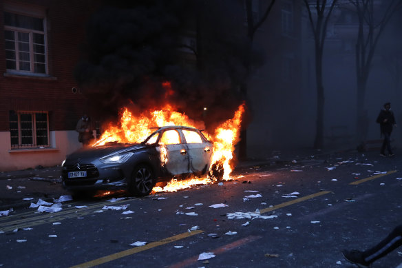 A car burns during the demonstration in Paris. 