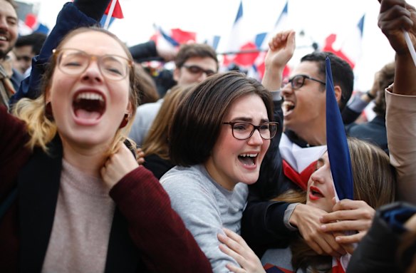 Supporters of French independent centrist presidential candidate, Emmanuel Macron react outside the Louvre museum in Paris, France.