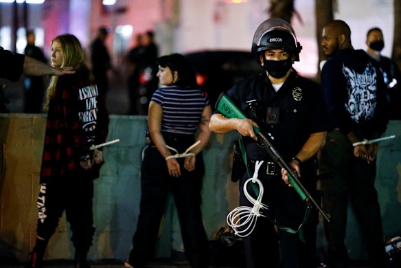 A police officer stands guard as demonstrators are detained during a protest on election night in Los Angeles.
