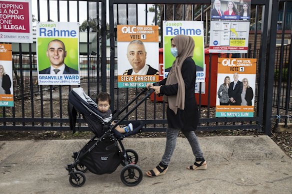 A woman arrives with her baby, at Merrylands East Public School, to vote in the local council elections, Merrylands, Sydney.