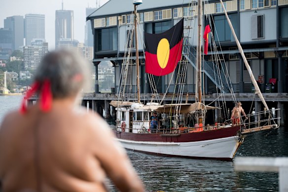 Indigenous flag bearing boat arrivies at the Australia Day smoking ceremony, Barangaroo, Sydney, 2020.