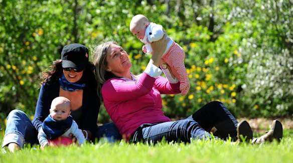 Canberra Capitals coach Carrie Graf, with partner Camille Chicheportische and baby twins Bentley (in blue ) and Charli (in red).