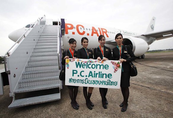 PC Air transsexual flight attendants (L to R):  Nathatai Sukkaset, 26,  Dissanai Chitpraphachin, 24, Chayathisa Nakmai, 24, and, Phuntakarn Sringern, 24, pose for photographers in front of a PC Air plane at Surat Thani Airport.