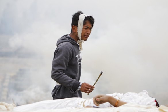 A Nepalese man performs rituals during the cremation of his mother who died in the earthquake in Bhaktapur near Kathmandu, Nepal, Sunday, April 26, 2015. 