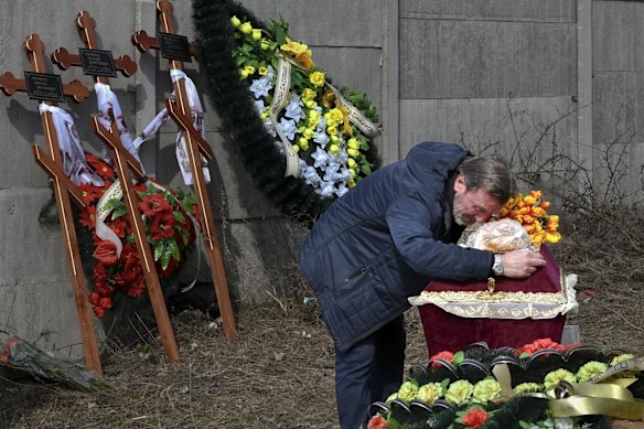 A relative mourns over the coffin containing 3 year-old Mykola Goryainiv, who died with his parents as they were driving a car trying to evacuate from a fighting zone in the Kharkiv region, at the funeral ceremony in Kramatorsk, Ukraine.