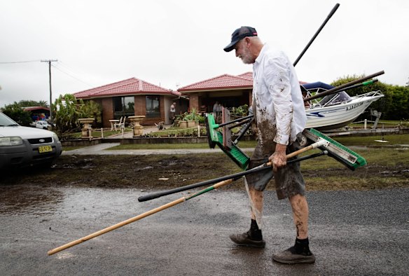 John Stobart brings brooms for the dozen volunteers helping to clean Bruno Temporini's Wardell home in the Northern Rivers region which was inundated with flood waters. Bruno, who has stage 4 cancer, is unable to do any cleaning, but a large group of volunteers have taken charge and are doing it for him.