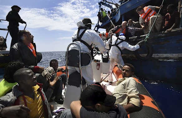 Refugees attempting to cross from Libya to Europe on a wooden boat carrying 565 people are rescued off the Libyan coast by Migrant Offshore Aid Station crew.