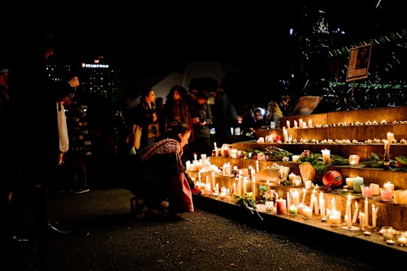 A supporter is seen lighting candles in remembrance of Eurydice Dixon at a vigil held in Elder Park in Adelaide.
