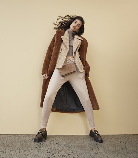 Camilla and Marc “Jonah” coat, $999, and “Berlin” jacket, $750. Zara knit top, $40, and track pants, $60. Reliquia “Coralia” hoop earrings, $139, and “Minx” necklace, $199. Fendi bag, $2190. Louis Vuitton “Academy” loafers, $1830. 