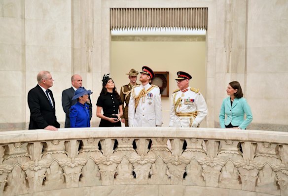 Britain's Prince Harry, center, and his wife Meghan, center left, the Duchess of Sussex and Governor of New South Wales David Hurley view the Hall of Memory at the official opening of Anzac Memorial at Hyde Park in Sydney.