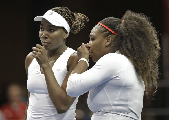 Venus Williams, left, and Serena Williams , right, talk between points in their doubles match against Netherlands' Leslie Herkhove and Demi Schuurs in the first round of Fed Cup tennis competition on February 11, 2018.