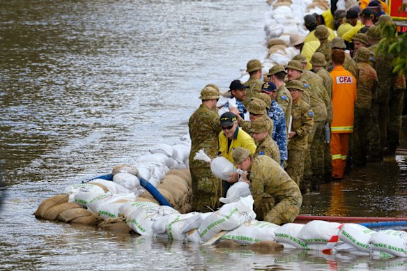 The CFA, army, and airforce work together to sandbag along the Campaspe River in Echuca West. 