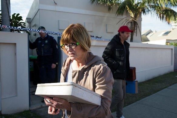 A resident is allowed back into her storm damaged property at Collaroy to collect some personal possessions.