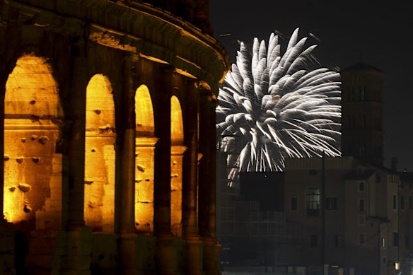 Fireworks explode in the sky next to Rome's Colosseum during New Year's celebrations, in Rome, Italy