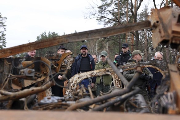 European Council President Charles Michel, centre, looks at destroyed vehicles as he is given a tour of the region of Borodyanka.