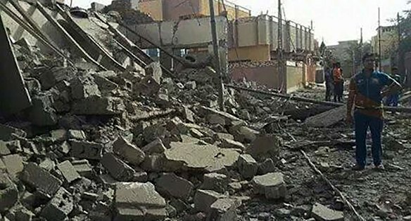 People stand amongst the destroyed buildings in the streets of Fallujah, a city under the control of the Islamic State, also known as ISIS. Fallujah, Iraq.