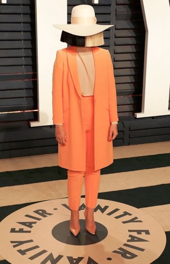 Australia's Sia wore a custom Giorgio Armani silk crepe orange long jacket with matching slim-cut trousers and a nude silk blouse to the Vanity Fair party.