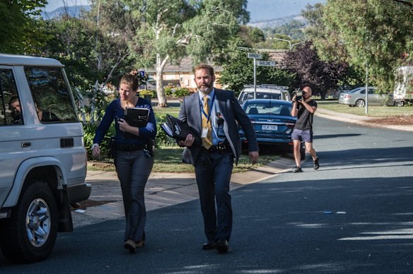 Police officers and forensic staff attend the scene of an overnight shooting and arson attack in Harrington circuit, Kambah. Numerous bullets have hit the home and three vehicles have been set alight. 