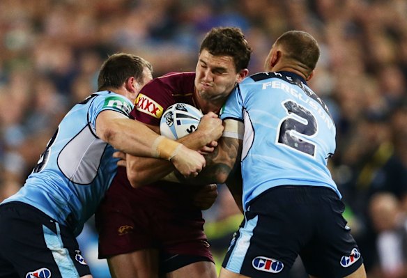 Corey Oates of the Maroons is tackled.