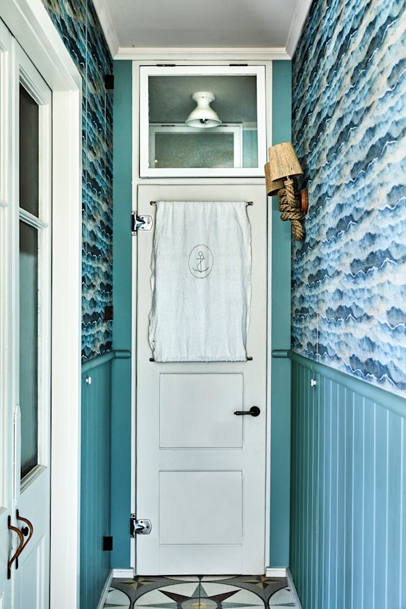 A petite hallway, papered and tiled in
Court’s own designs, leads to her laundry, with a powder room on the left.