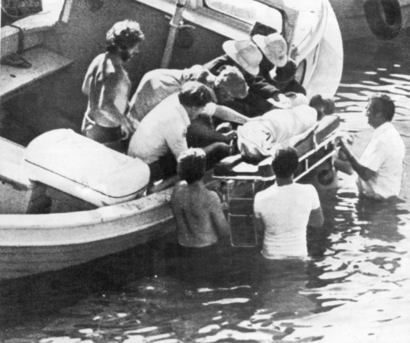 "Rescue workers lift an unidentified body from a small boat in Mullaghmore harbour Monday, after an explosion aboard a fishing boat Killed Earl Mountbatten of Burma, and two other people."